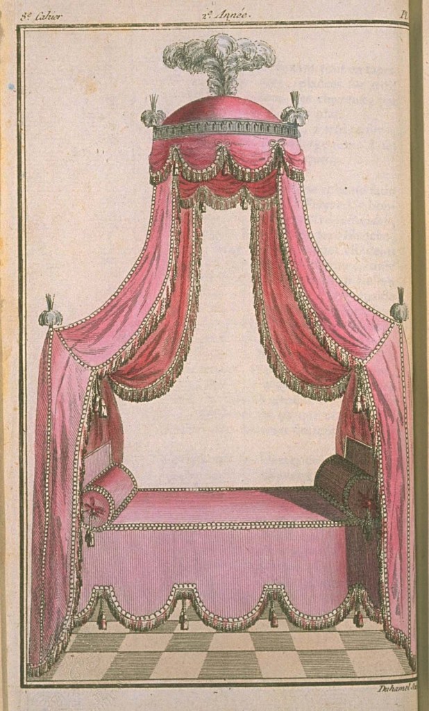 A bed with a pink canopy, edged in white fringe. There is a dome on top with feathers, and a round bolster at either end of the bed.